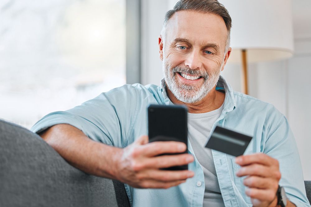 Foto: Mann mit Mobiltelefon und Kreditkarte